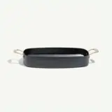 A sleek, rectangular baking dish with metallic handles and a matte black finish.