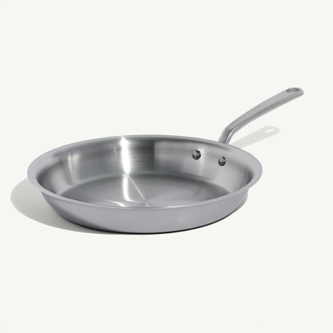 A stainless steel frying pan with a long handle on a white background.