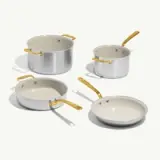 A set of four cooking pots and pans with metallic exteriors and gold-toned handles, featuring a sleek design.