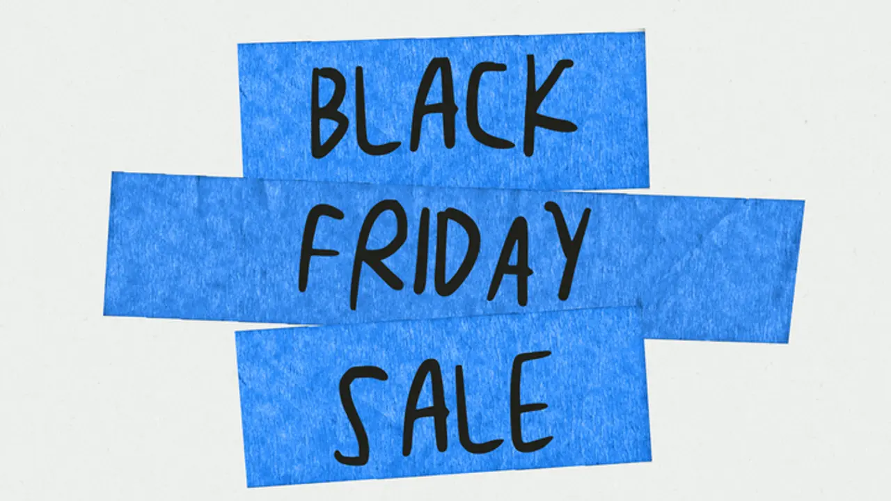 Two strips of blue tape cross each other on a light background, with the words "BLACK FRIDAY SALE" written in black marker.