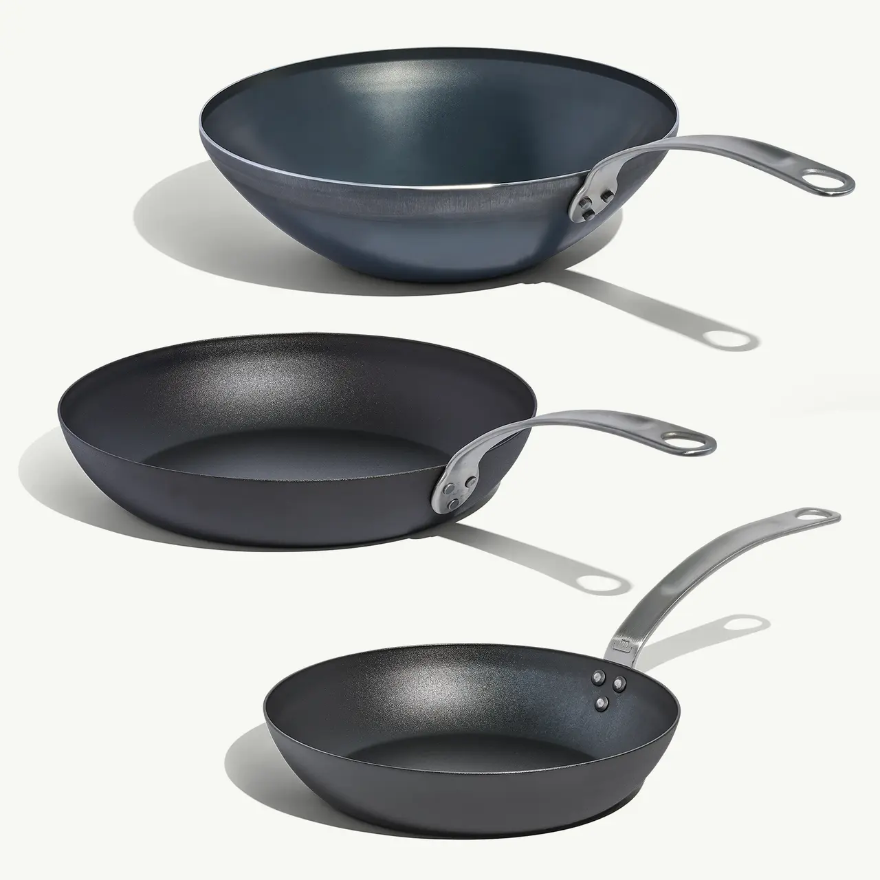 Three cookware items in varying sizes and shapes, featuring a modern design and a sleek, dark finish.