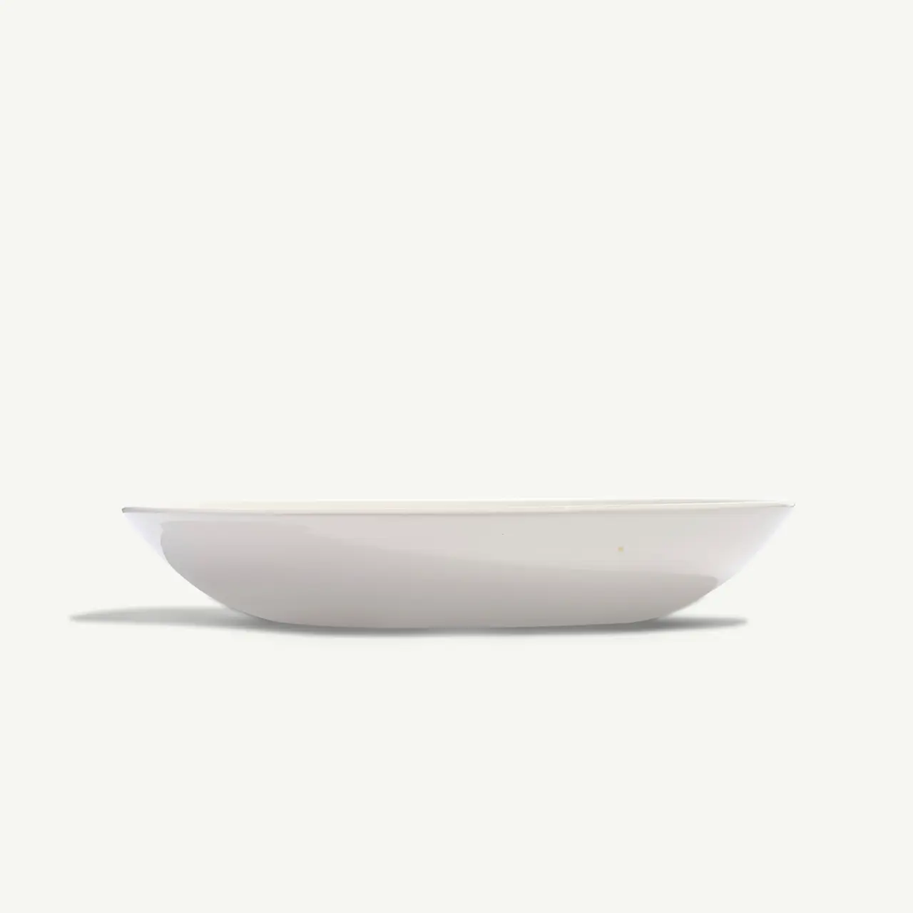 A plain white, shallow bowl is centered on a white background.