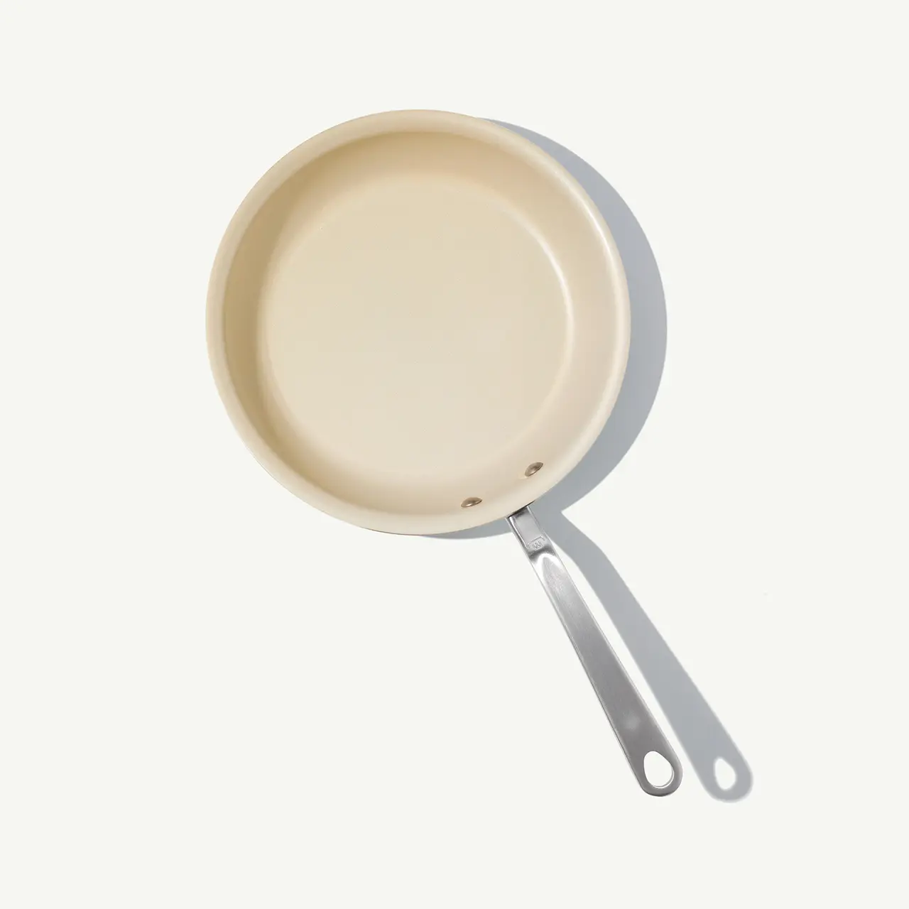 A beige non-stick frying pan with a silver handle is displayed against a light background.