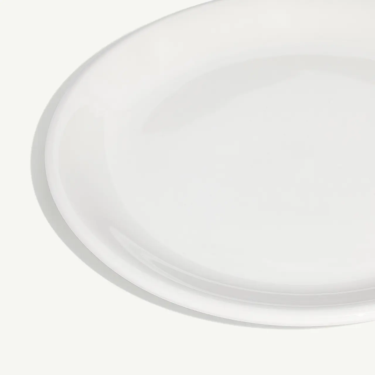 A plain white circular plate is displayed against a light background.