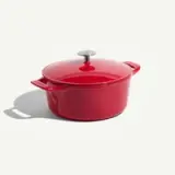 A vibrant red cast iron Dutch oven with a matching lid and metal knob.