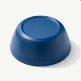 A blue, round plastic bowl is shown upside down.