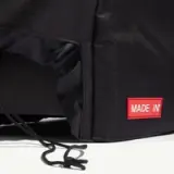 A black fabric bag featuring a prominent red "MADE IN" label and a drawstring closure.