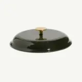 A round, glossy green lid with a gold handle sits on a plain background.