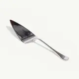 A single, shiny metal spoon lies isolated on a plain, light background.
