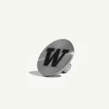 A silver pin featuring a bold black letter "W" on a reflective surface.