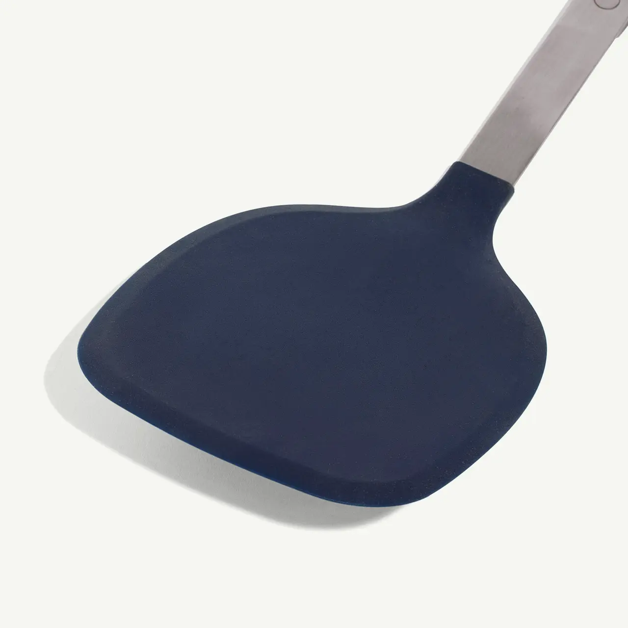 A close-up of a blue silicone spatula against a white background.