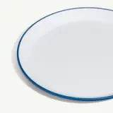 A plain white plate with a blue rim is displayed on a light background.