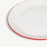 A close-up of a white circular plate with a thin red border against a light background.
