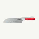 A stainless steel chef's knife with a red handle and dimpled blade lies against a white background.