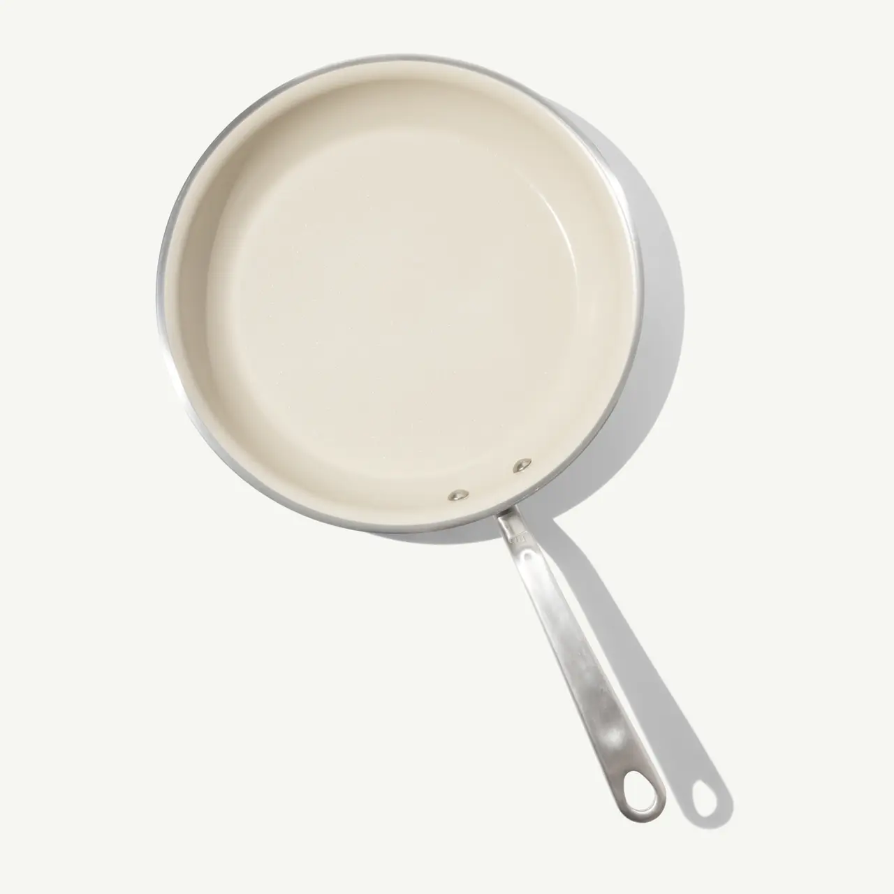 A white, circular frying pan with a stainless steel handle and no visible food.