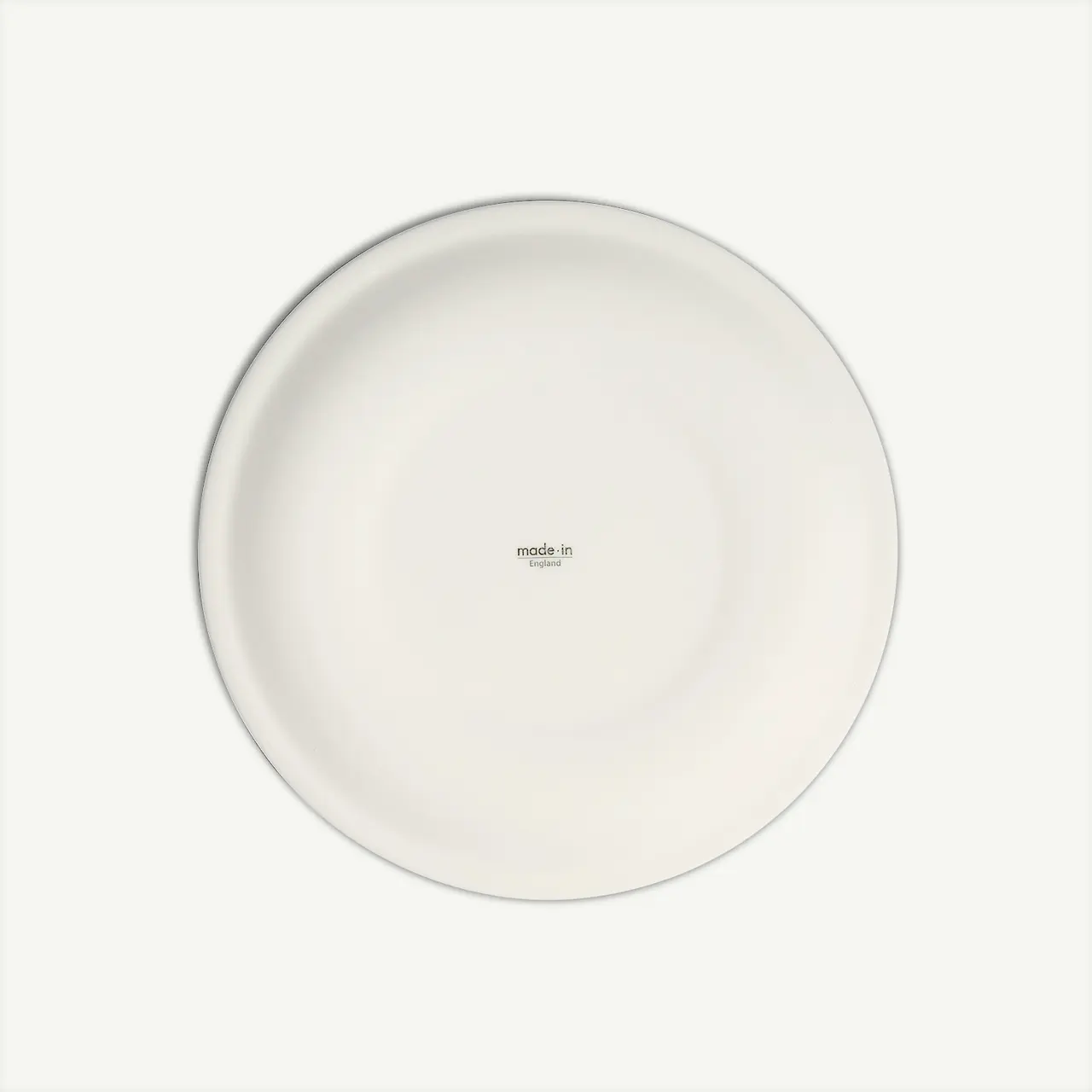 A plain white circular plate with a small "made.in" text in the center is depicted against a white background.