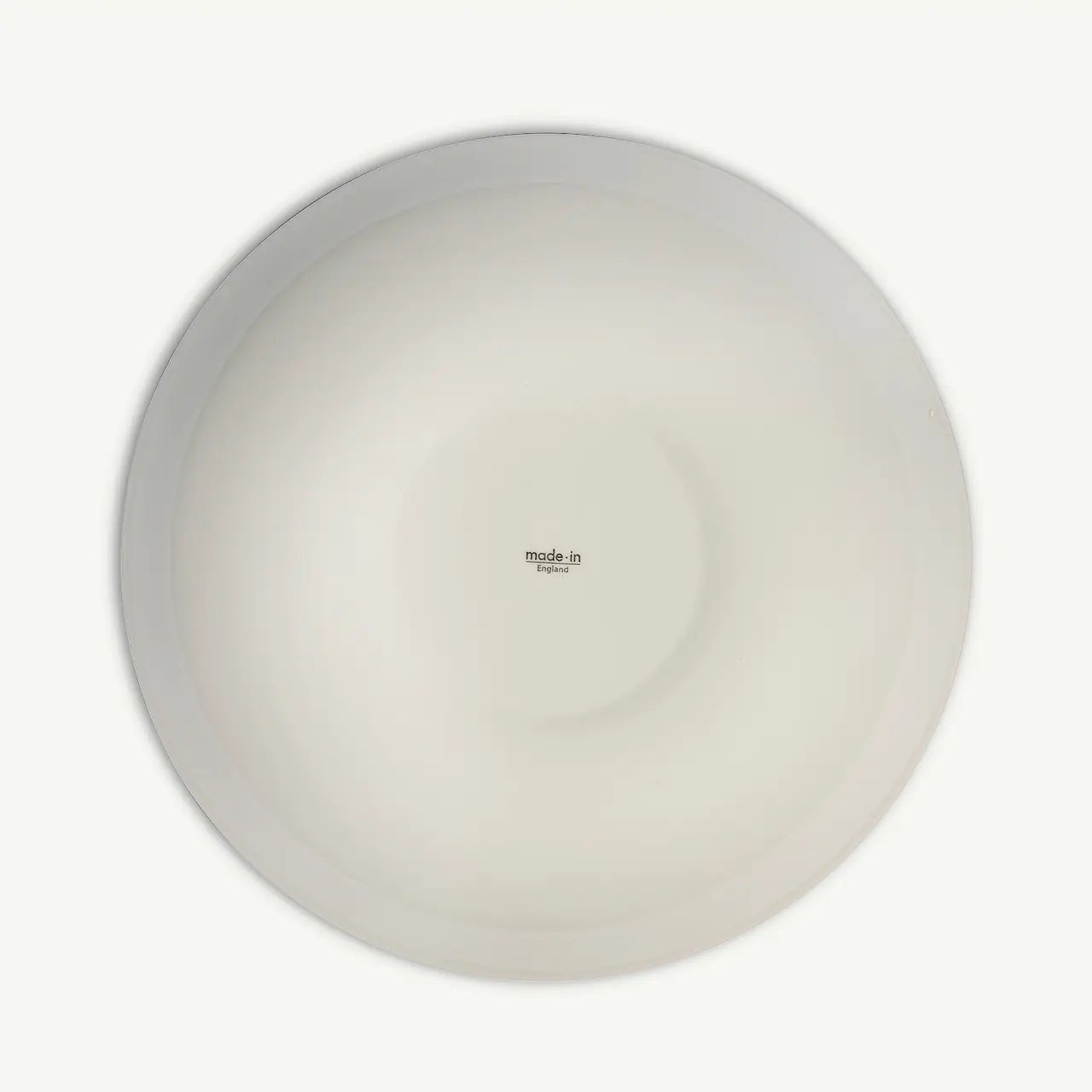 A plain white circular plate with a small "made.in" text at the center is displayed against a white background.