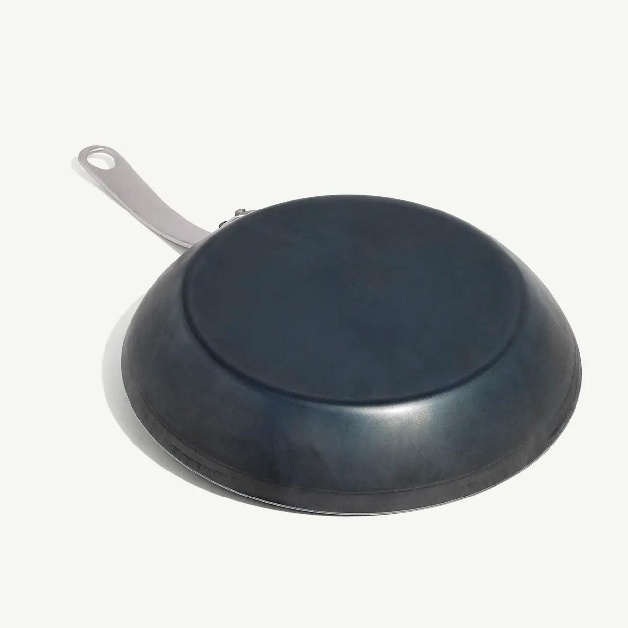 An upside-down frying pan with a silver handle on a white background.