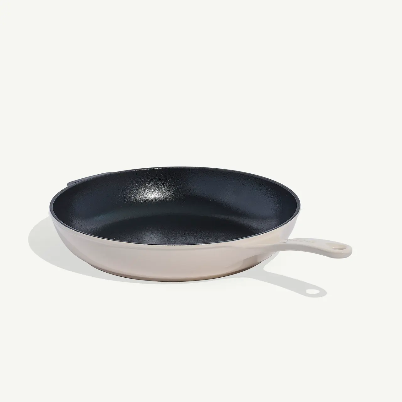 A non-stick frying pan with a beige handle on a plain background.