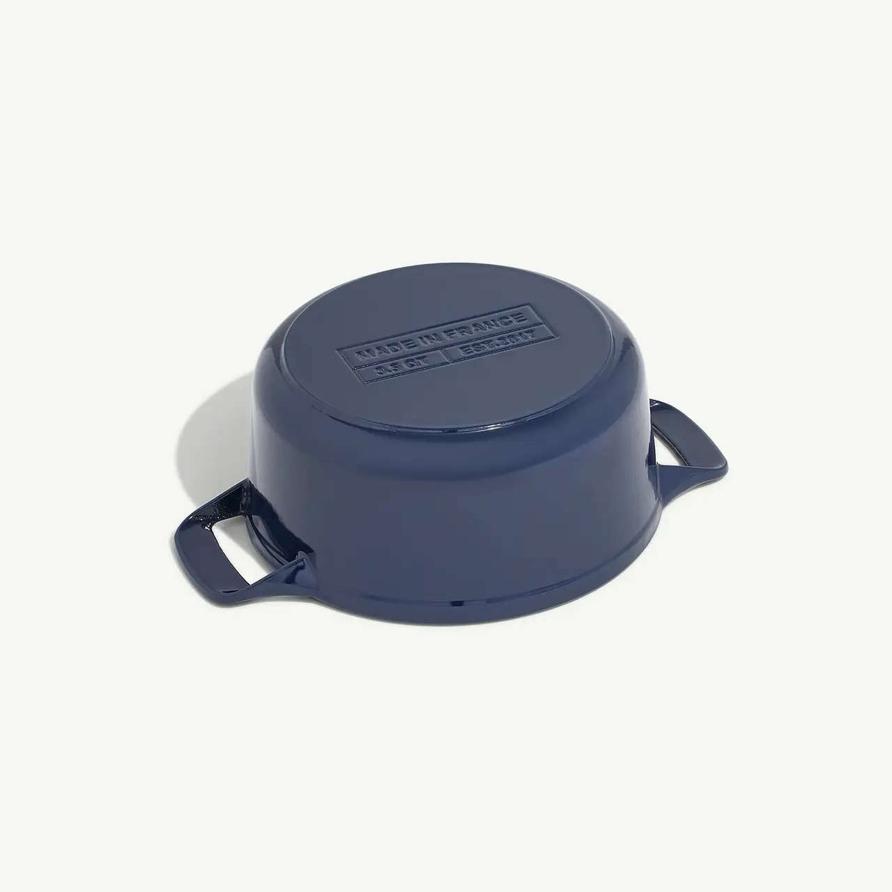 A blue enameled saucepan lid with two handles, viewed from above on a white background.
