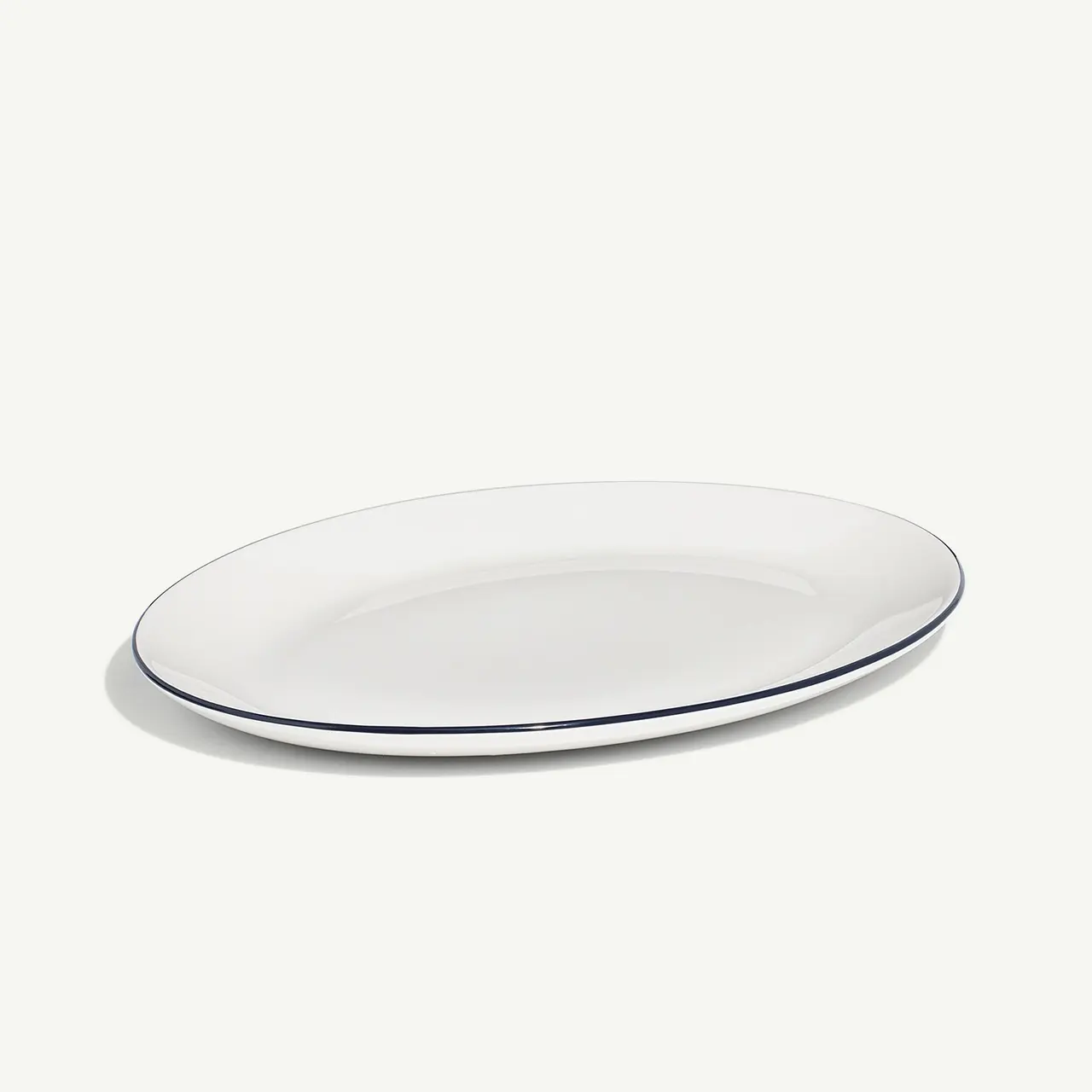 A plain white oval plate with a thin blue rim on a neutral background.