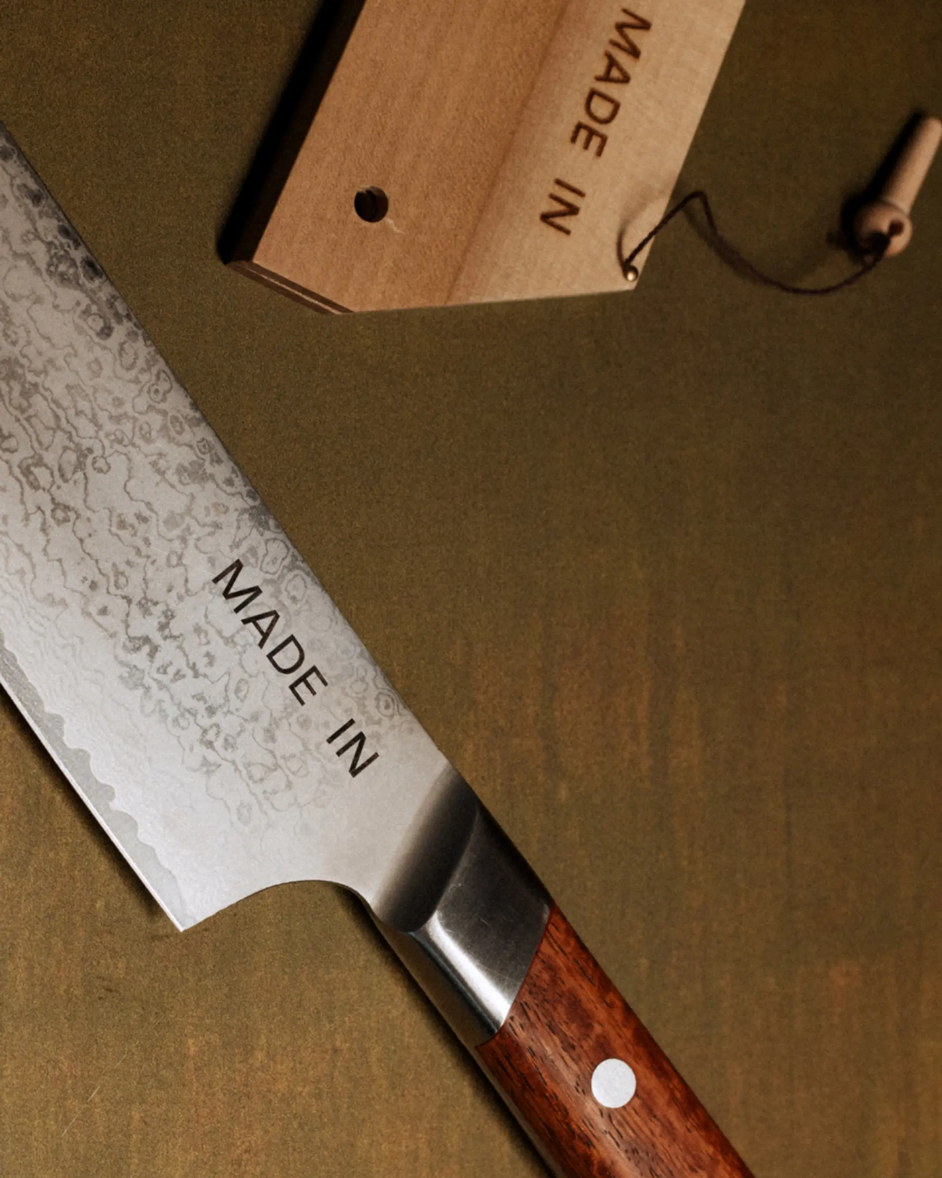 A close-up of a kitchen knife with a wooden handle shows "MADE IN" inscribed on the blade, alongside its packaging tag repeating the phrase.