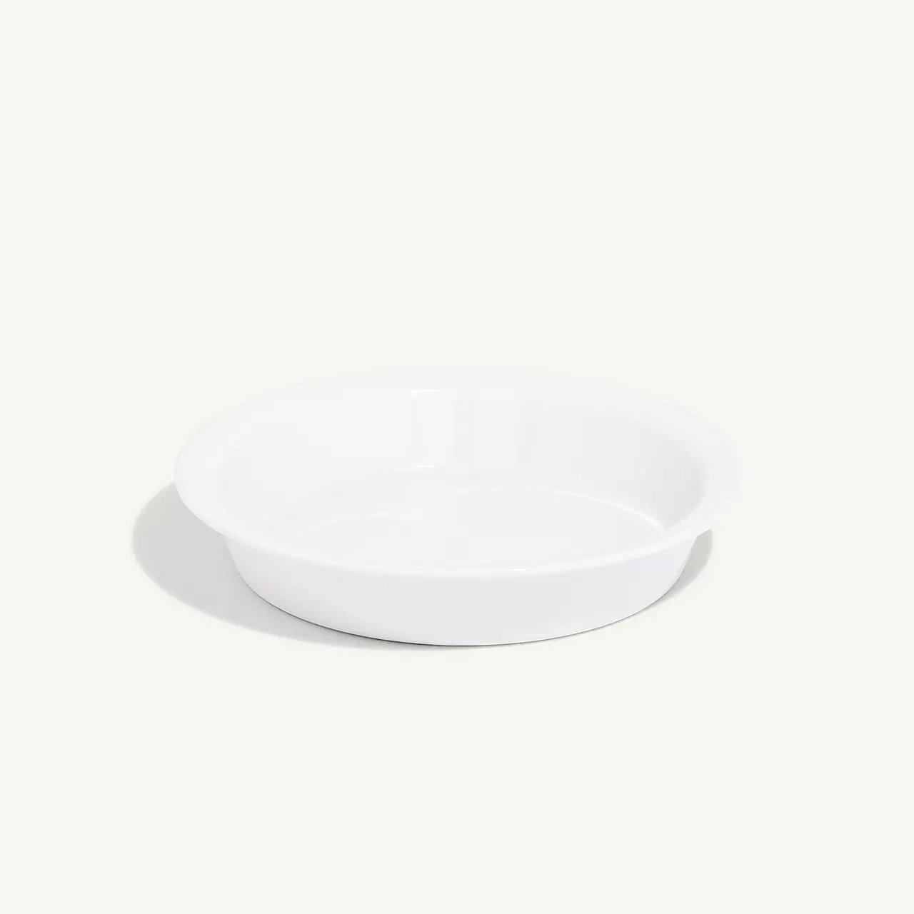 A simple white shallow bowl is centered on a plain background.