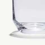 A clear glass with a simple, modern design is displayed against a light background.