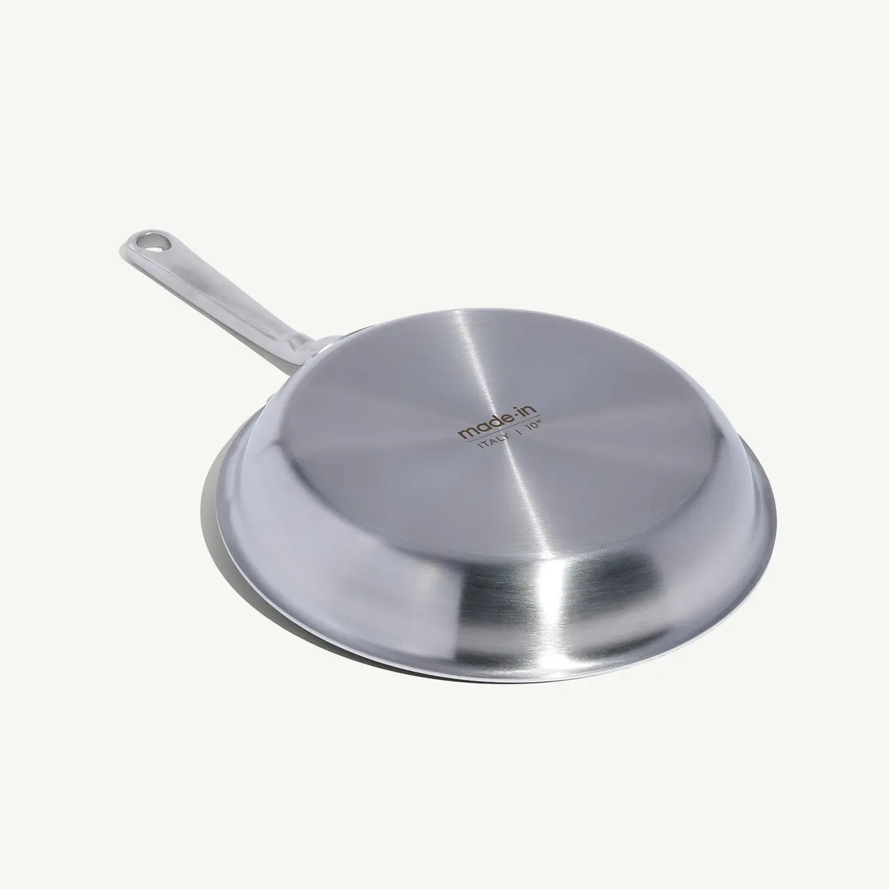 A stainless steel frying pan with a long handle is displayed against a white background.