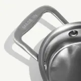 A shiny stainless steel pot with a handle inscribed with "MADE IN."