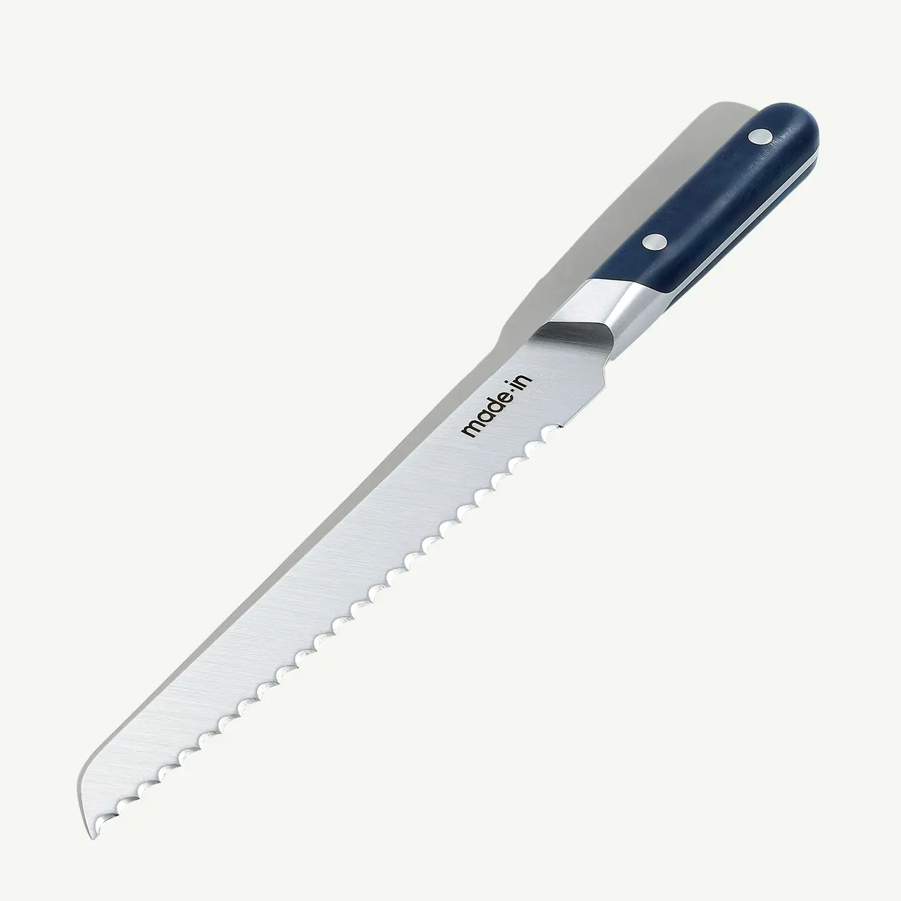 A serrated bread knife with a blue and black handle lies against a white background.