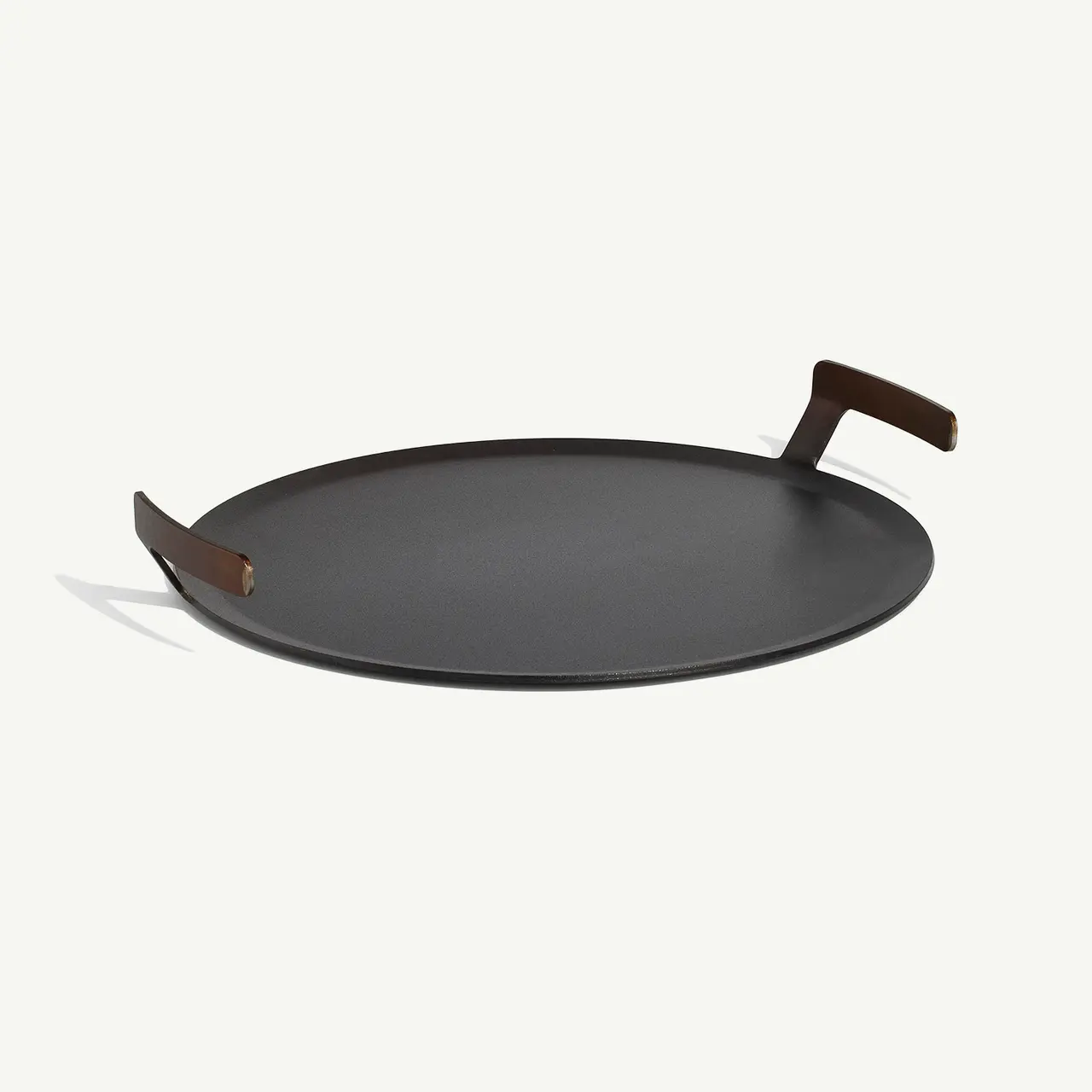 A black round frying pan with a brown handle, isolated on a light background.