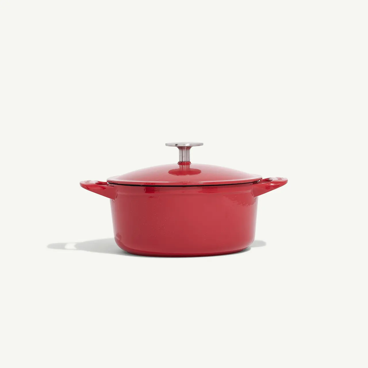 A red cooking pot with a lid centered against a white background.
