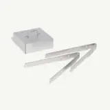 A set of metal grilling accessories, including a square box with a handle and two elongated grill scrapers.