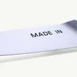 A shiny metallic surface features the text "MADE IN" prominently engraved on it.