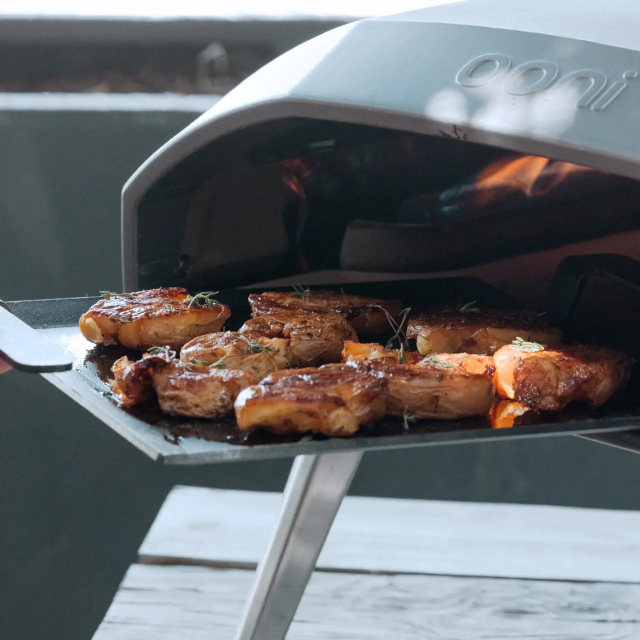 Juicy steaks are grilling over an open flame inside a barbecue grill.