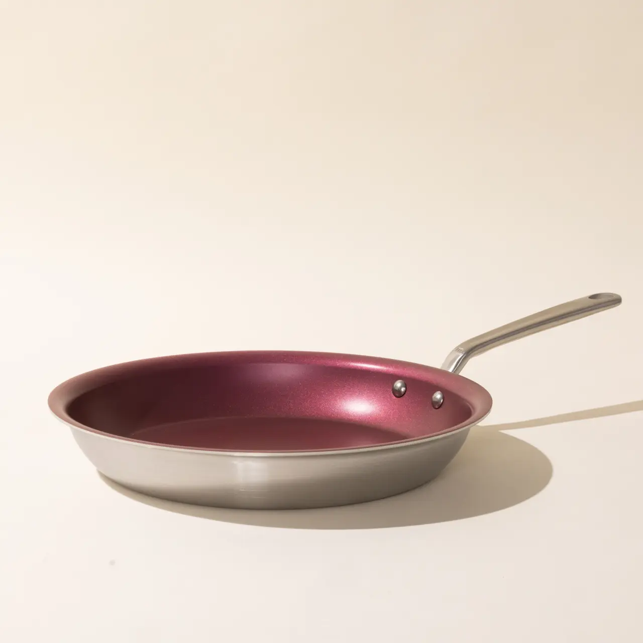 A new non-stick frying pan with a stainless steel handle on a light background.