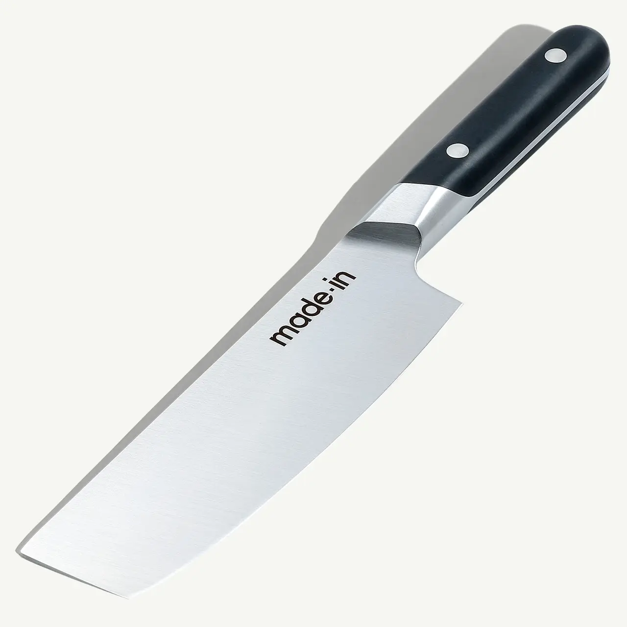 A stainless steel kitchen knife with a black handle and the brand "made.in" etched on the blade.