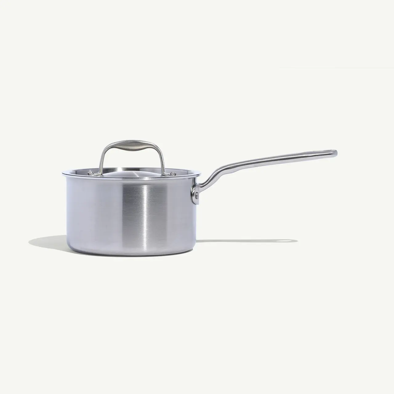 A stainless steel saucepan with a long handle against a white background.