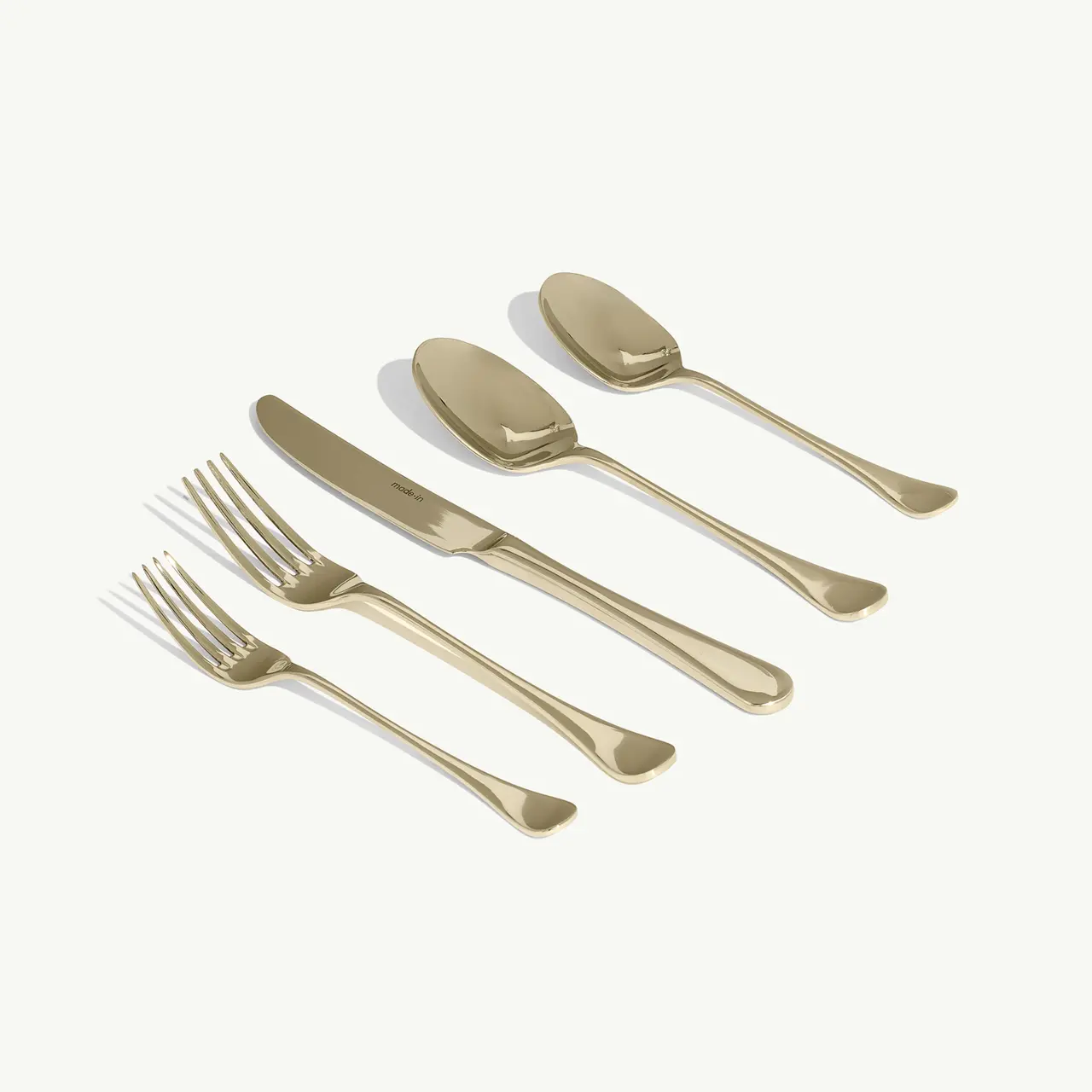 Made In 20-Piece Champagne Flatware set with champagne-tone forks, a knife, and spoons arranged diagonally.