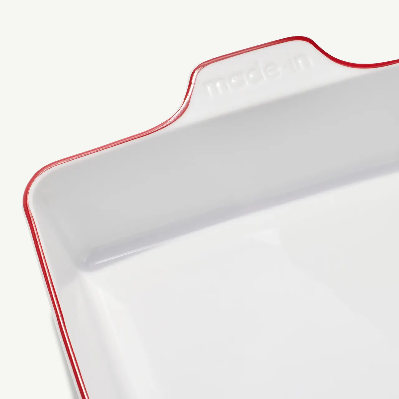 A white square serving tray with a red rim and the word "modern" embossed on one side.