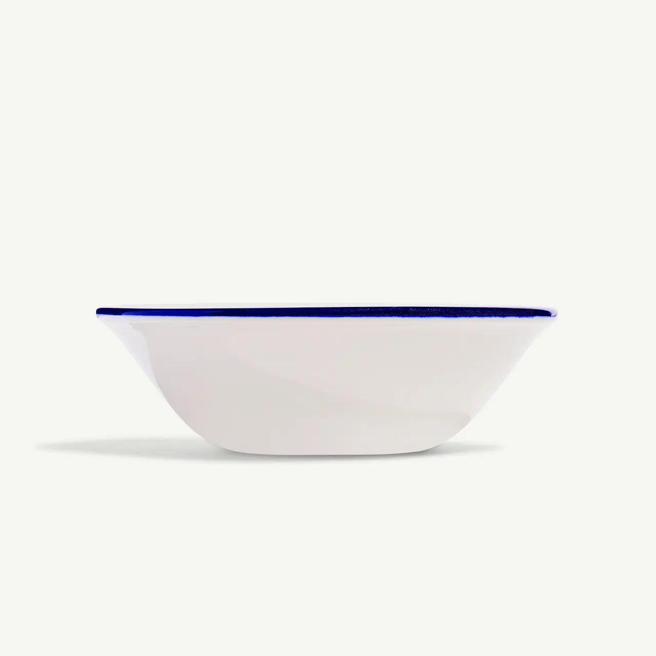 A white bowl with a blue rim on a white background.