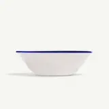 A white bowl with a blue rim on a white background.