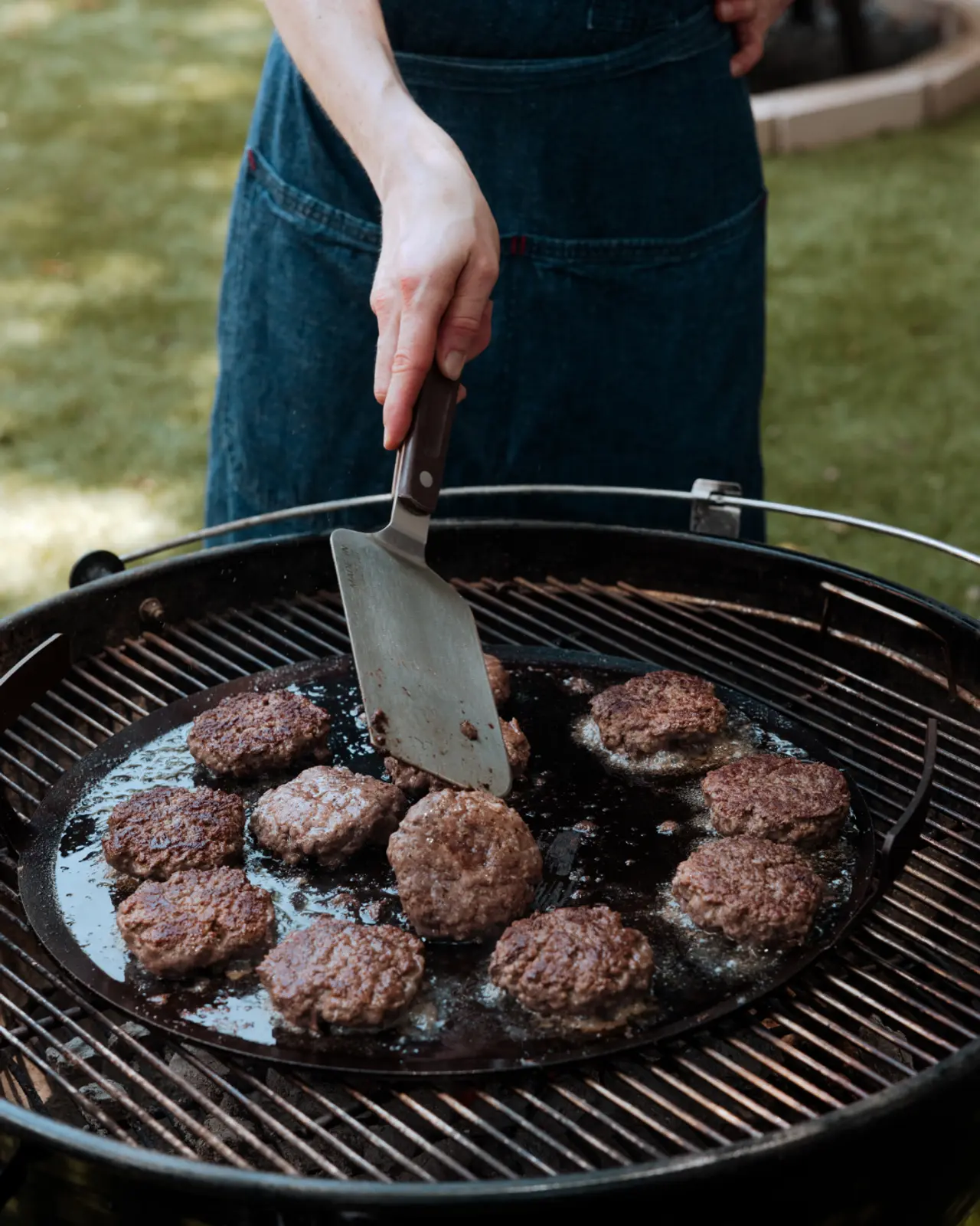 burgers being flipped on a griddle