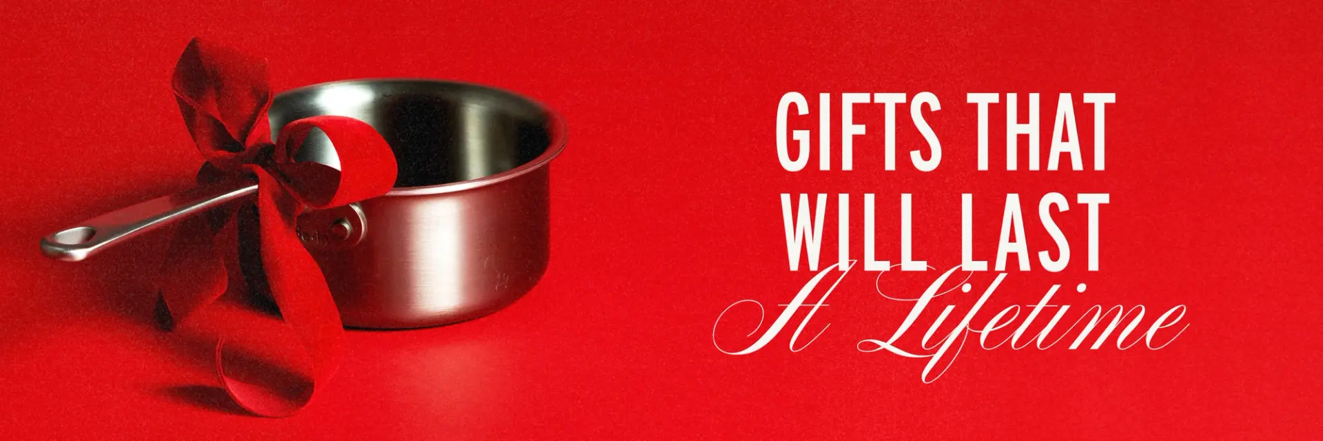 A stainless steel pot adorned with a red ribbon is set against a vibrant red background, accompanied by the text "Gifts That Will Last A Lifetime."