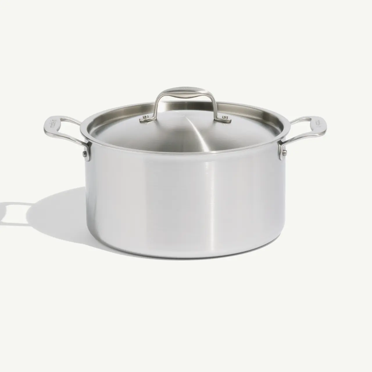 A stainless steel cooking pot with two handles and a lid, isolated on a white background.