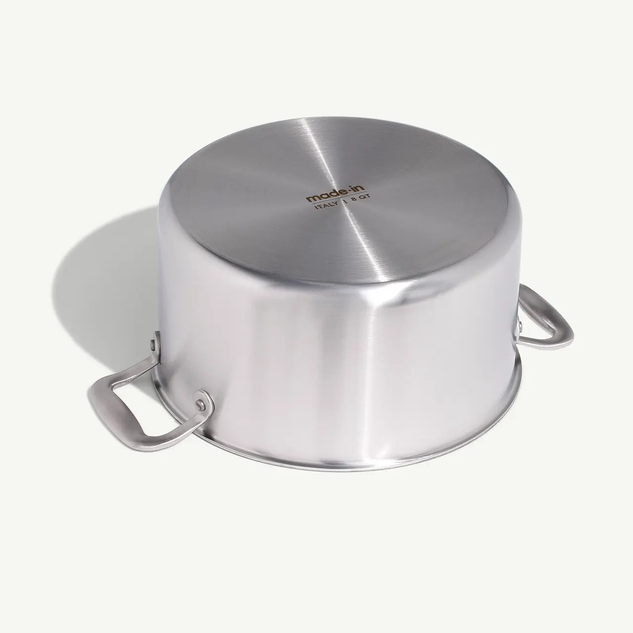 A stainless steel pot with two handles and a closed lid, displayed on a light background.