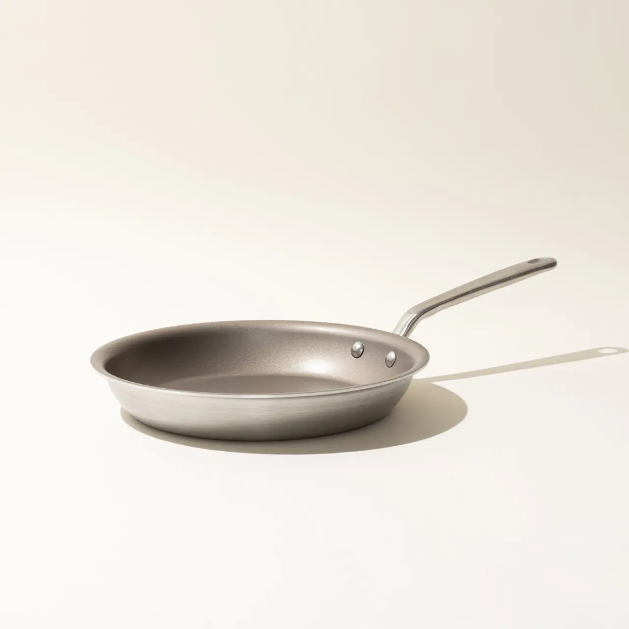 A single non-stick frying pan with a stainless steel handle on a neutral background.