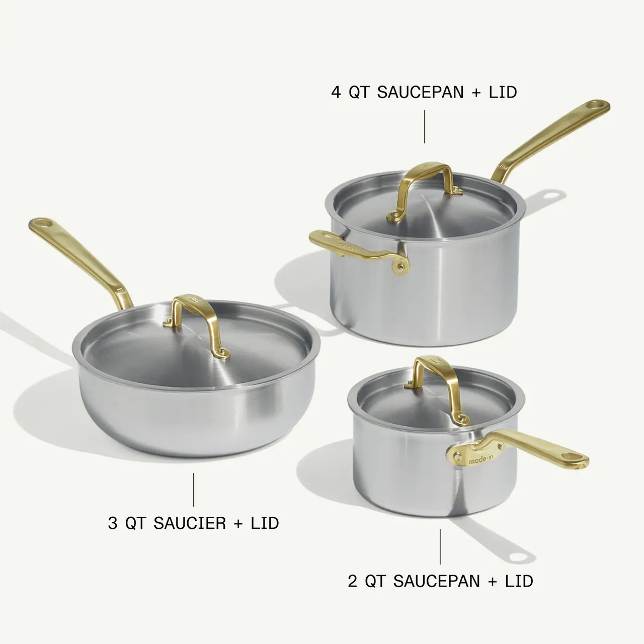 Three different sizes of silver cooking pots are displayed, including a 4-quart saucepan with lid, a 3-quart saucier with lid, and a 2-quart saucepan.
