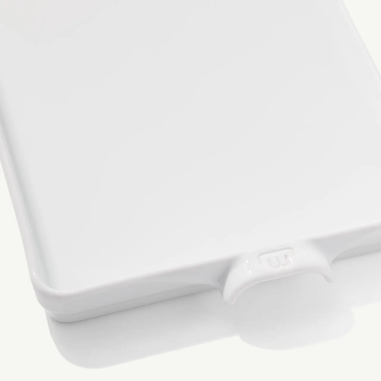 A close-up view of a white laptop with a visible USB port on its edge.